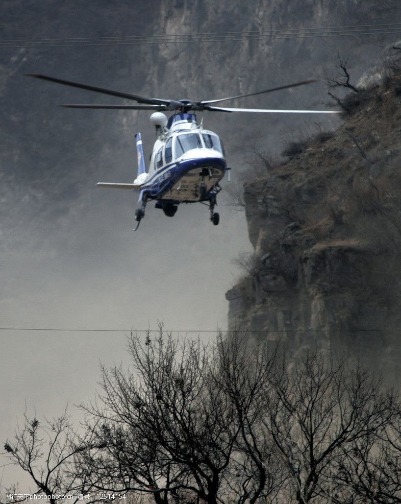 警用直升机在山谷超低空飞行图片